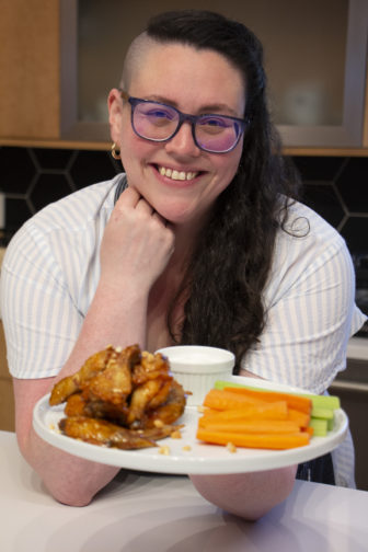 Genny holding a plate of buffalo wings